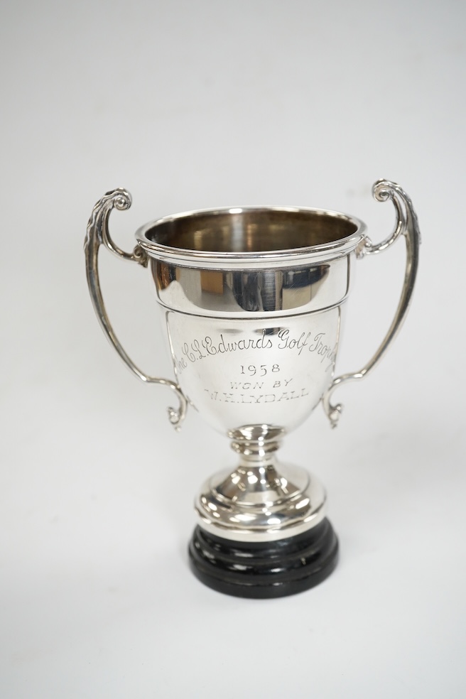 A pair of Edwardian silver dwarf candlesticks, of tapering design, C.S Green & Co, Birmingham, 1908, 13.2cm, together with four small silver trophy cups, a silver napkin ring and a plated trophy cup. Condition - poor to